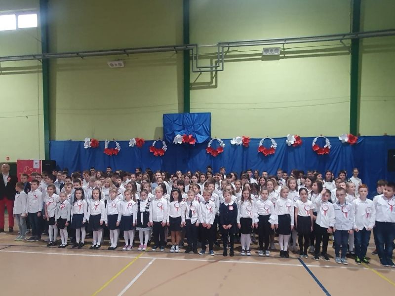 Na zdjęciu uczniowie SP nr 6 w odświętnych strojach podczas śpiewania hymnu na sali gimnastycznej